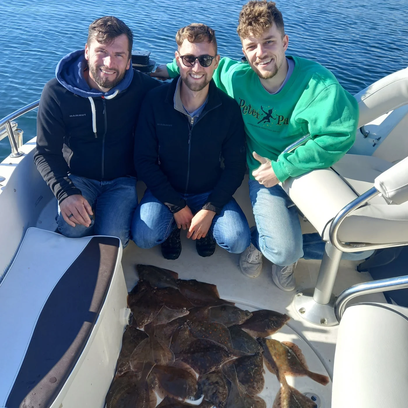 Tre fiskegæster ombord med dagens fangst