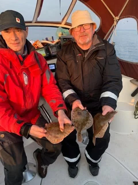 To fiskegæster med rødspætter på fødselsdagsturen